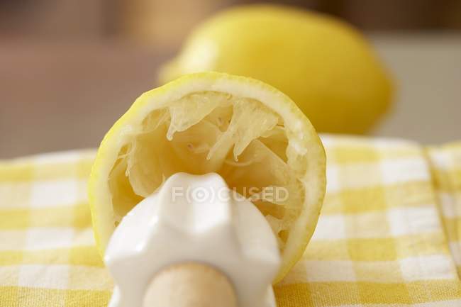 Medio limón exprimido con exprimidor - foto de stock