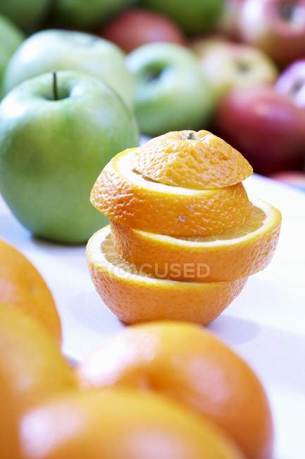 Manzanas frescas y rodajas de naranja apiladas - foto de stock