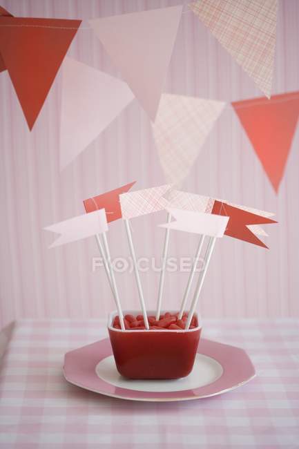 Doces com bandeiras de papel decorativo em tigela — Fotografia de Stock