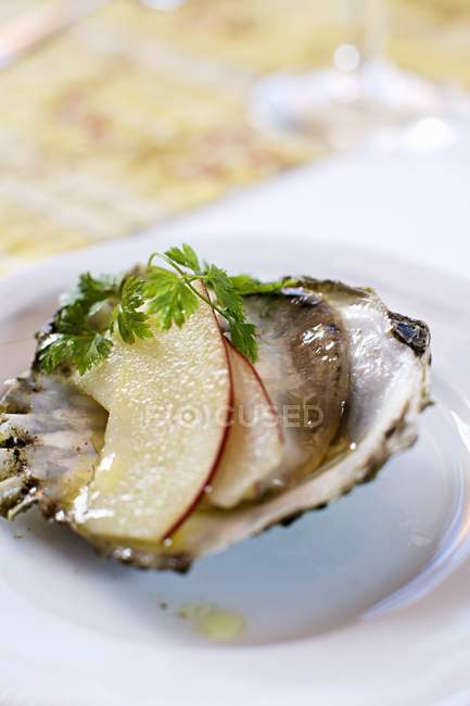 Oyster with slices of apple  on white plate — Stock Photo