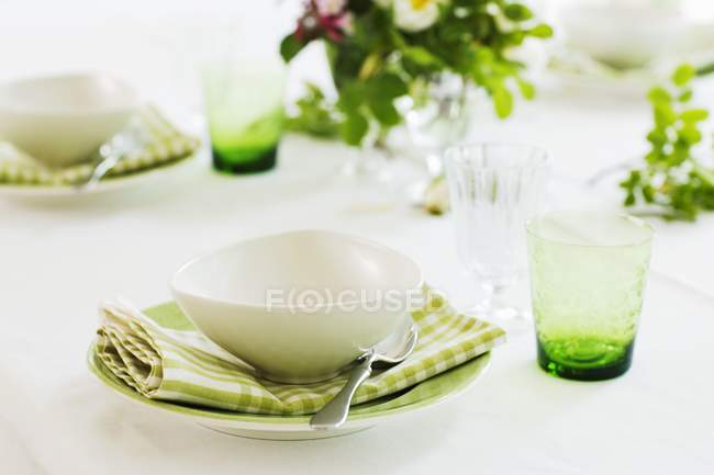 Крупный план установки места с тарелками для супа и цветочным декором — стоковое фото