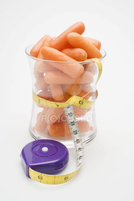 Baby carrots with tape measure — Stock Photo