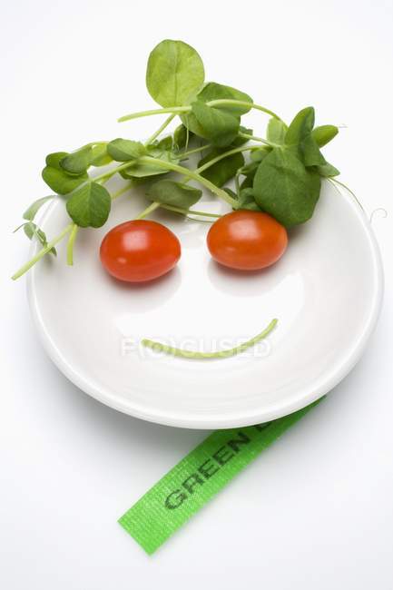 Овощное лицо в тарелке с супом, этикетка рядом с ним на белом фоне — стоковое фото