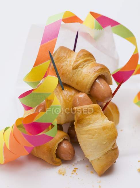 Sausage rolls with party decorations — Stock Photo