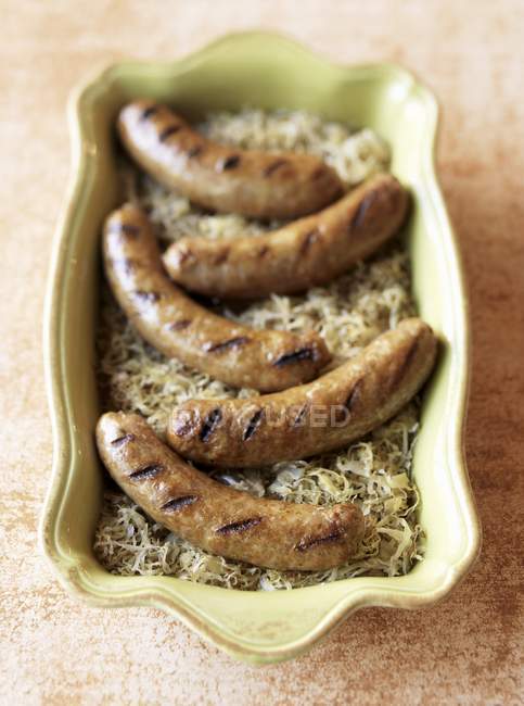 Grilled Bratwurst Over Sauerkraut — Stock Photo
