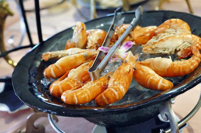 Cooked king prawns on ice cubes — Stock Photo