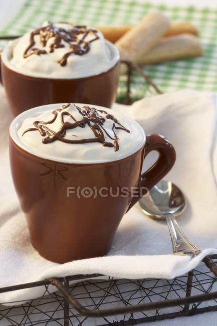 Hot chocolate in cups with cream topping — Stock Photo