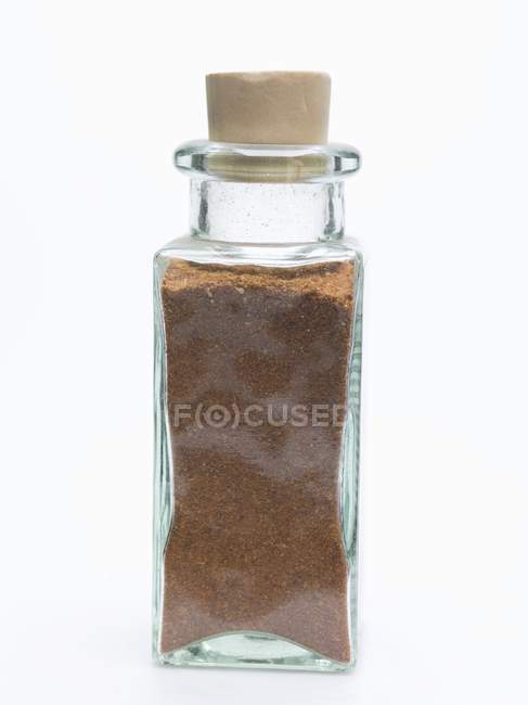 Вид крупным планом тертого мускатного ореха в маленькой стеклянной бутылке — стоковое фото