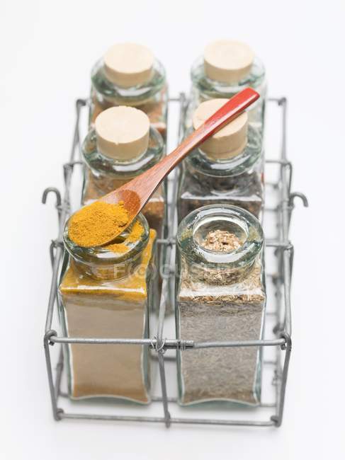 Closeup view of various spices in small glass bottles and on spoon — Stock Photo