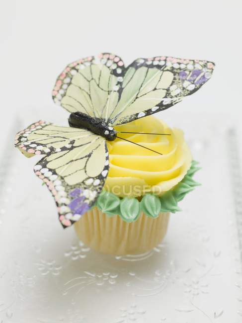 Rose muffin decorated with butterfly — Stock Photo
