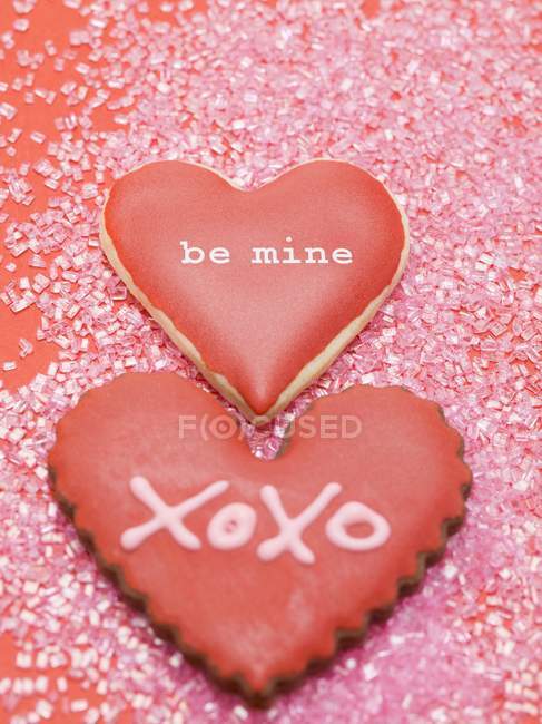 Closeup view of vanilla and chocolate hearts with red icing and writings — Stock Photo
