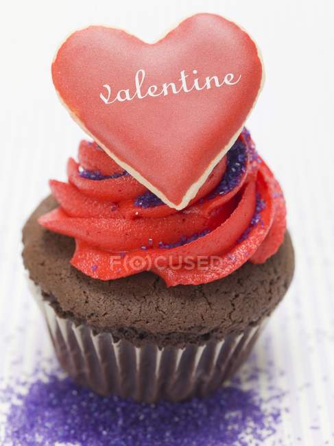 Chocolate muffin with red cream — Stock Photo