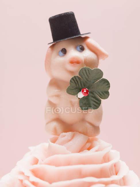 Closeup view of marzipan pig with four-leaf clover on cream — Stock Photo