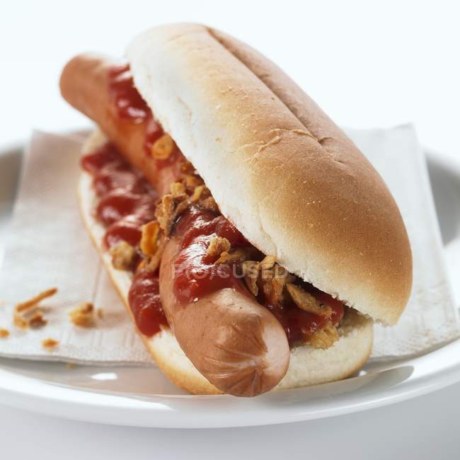 Hot dog with ketchup on plate — Stock Photo