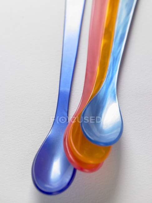 Vue rapprochée des cuillères en plastique coloré sur la surface blanche — Photo de stock