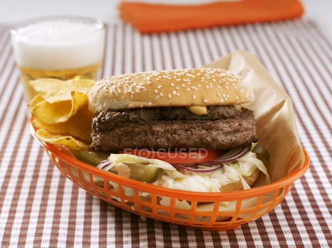 Hamburger et chips dans un panier en plastique — Photo de stock