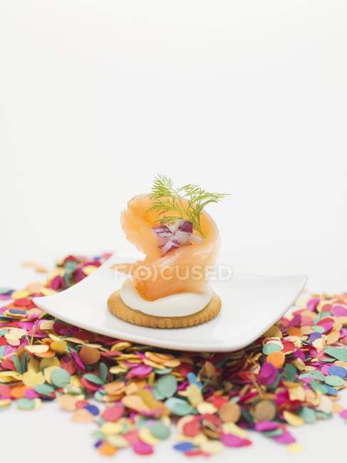 Копченый лосось на крекере на тарелке — стоковое фото