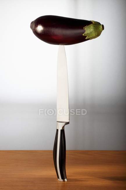 Aubergine speared on knife — Stock Photo