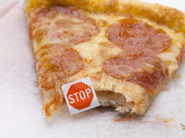 Slice of pizza with stop sign — Stock Photo