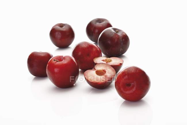 Ameixas vermelhas com metades — Fotografia de Stock