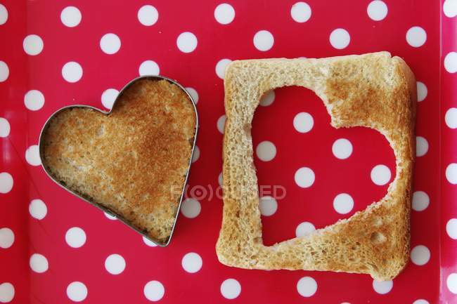 Closeup top view of a heart cut out of a slice of toast — Stock Photo