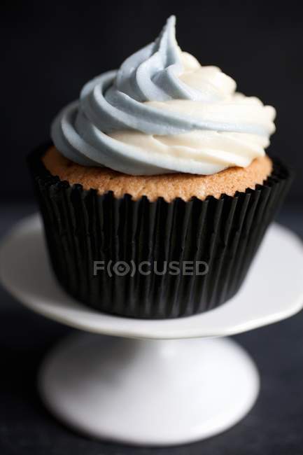 Cupcake with cream on stand — Stock Photo