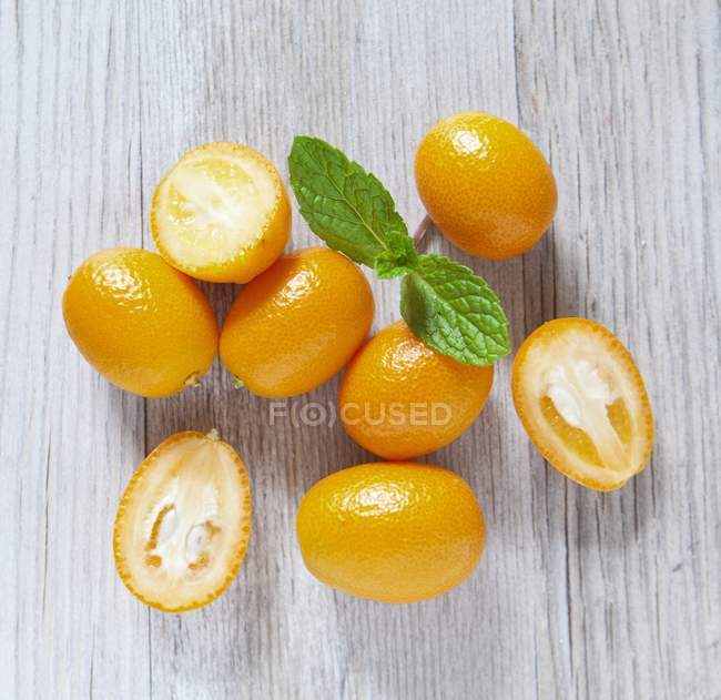 Kumquats maduros frescos con mitades - foto de stock