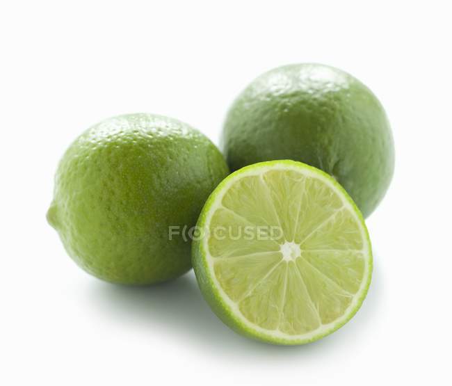 Limes fraîches avec la moitié — Photo de stock