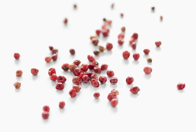 Scattered dried red peppercorns — Stock Photo