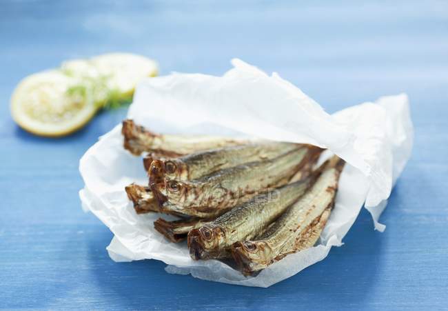 Pile of sprats on crumpled paper — Stock Photo