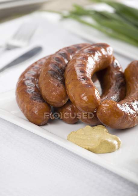 Grilled sausages with mustard — Stock Photo