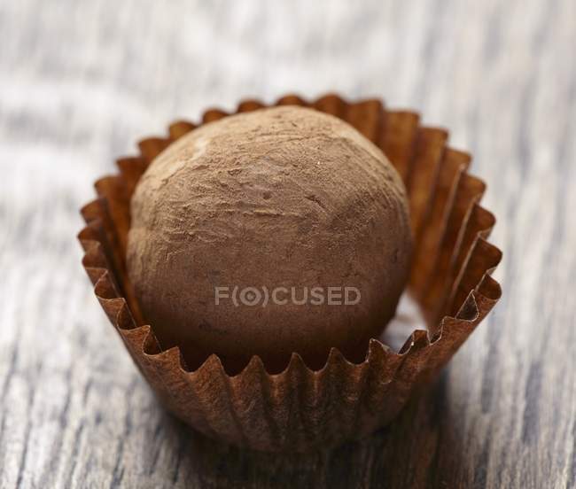 Trufa de chocolate sobre mesa de madera marrón - foto de stock