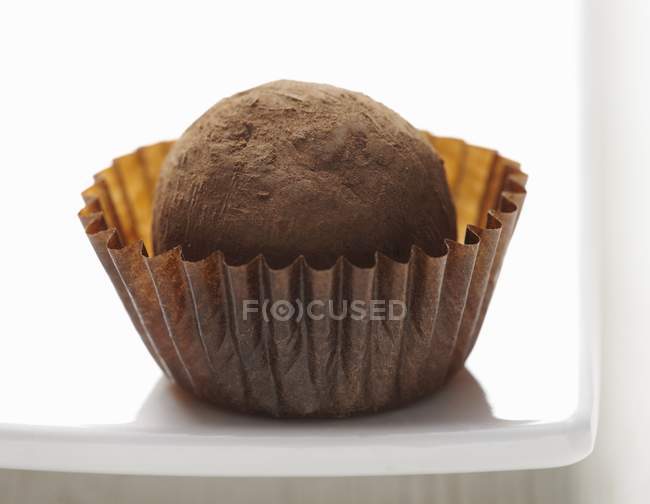 Chocolate truffle on white plate — Stock Photo