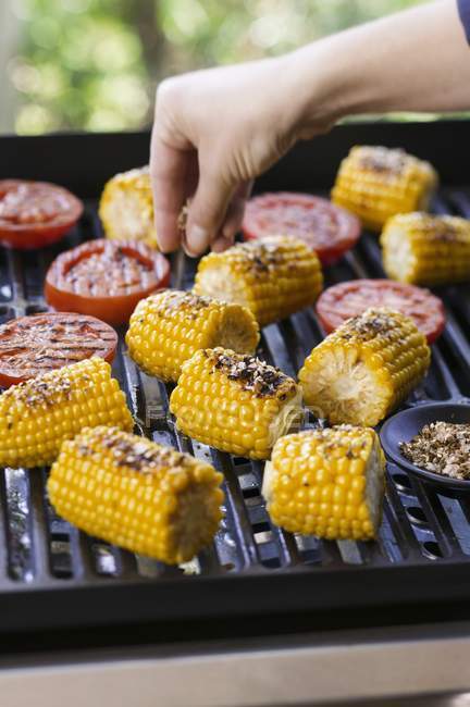 Corncob being seasoned on the barbecue — Stock Photo