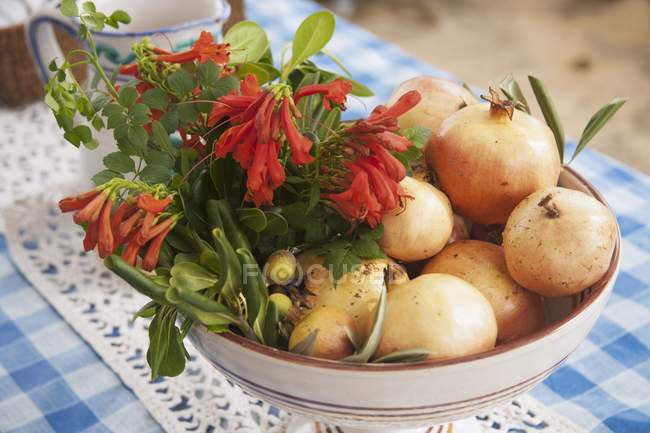 Closeup view of pomegranates with olive branches and flowers — Stock Photo