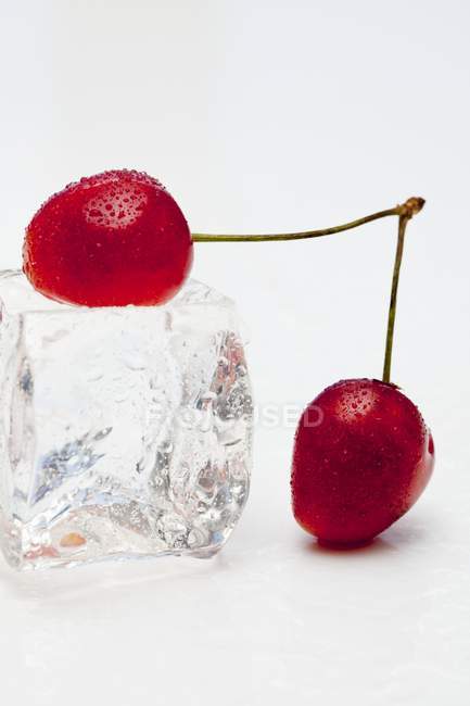 Cerejas vermelhas com cubo de gelo — Fotografia de Stock
