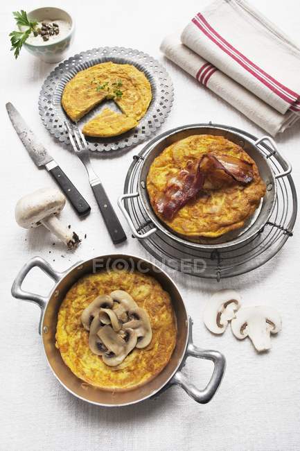 Potato omelettes garnished with mushroom, with bacon, and with fresh mint — Stock Photo