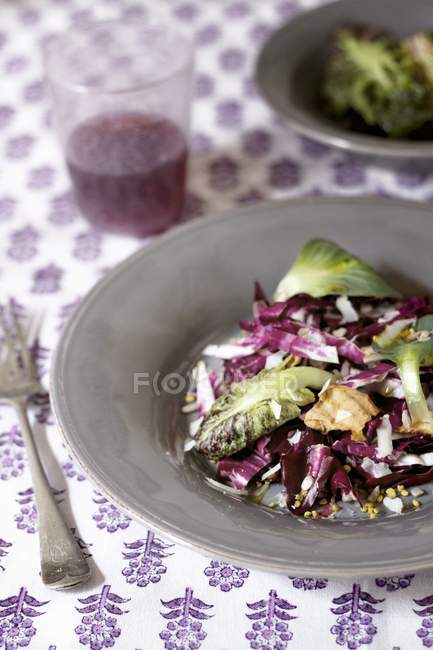 Radicchio salad on grey plate over tablecloth — Stock Photo