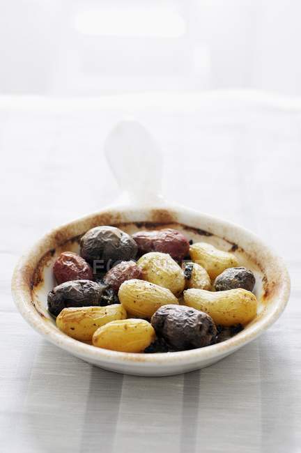 Uma tigela pequena de batatas assadas pequenas sortidas com Morels na placa branca sobre a toalha de mesa — Fotografia de Stock
