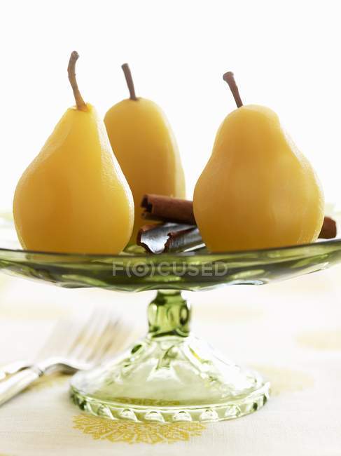 Pochierte Birnen auf Kuchen stehen über weißer Oberfläche — Stockfoto