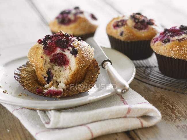 Half eaten berry muffin — Stock Photo