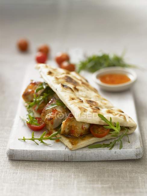 Flatbread with chicken on board — Stock Photo