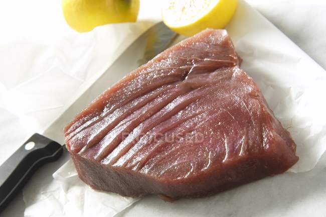 RAW тунця з ножем і лимони — стокове фото
