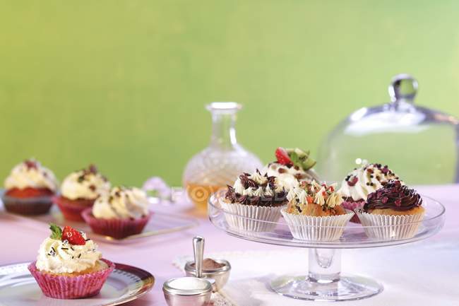 Assorted cupcakes on plates — Stock Photo