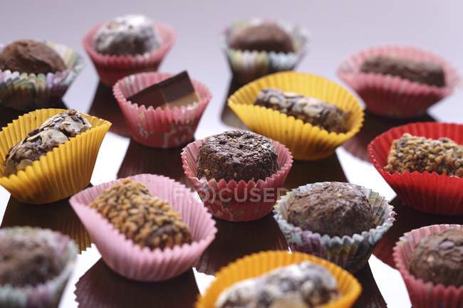 Chocolates cheios em caixas de papel coloridas — Fotografia de Stock