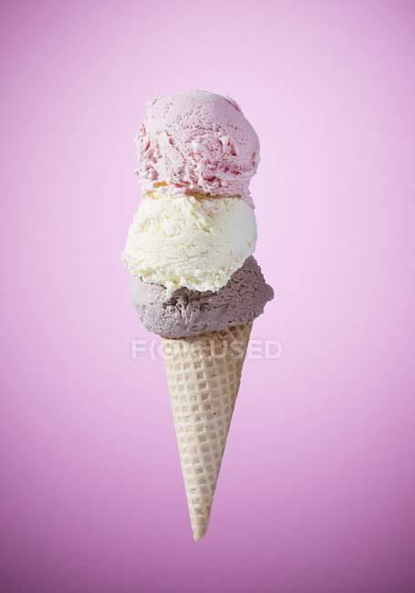 Cono con helado de fresa, vainilla y chocolate - foto de stock