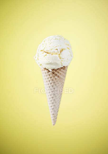 Ice cream cone with melting vanilla ice — Stock Photo
