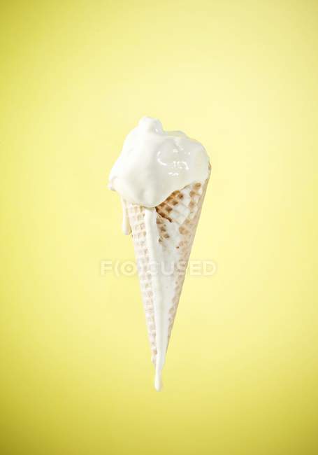 Ice cream cone with melting vanilla ice — Stock Photo