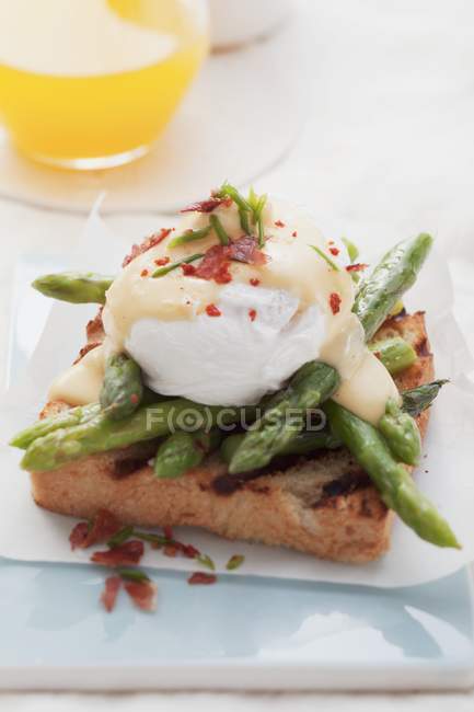 Toast with asparagus and Eggs Benedict on paper — Stock Photo