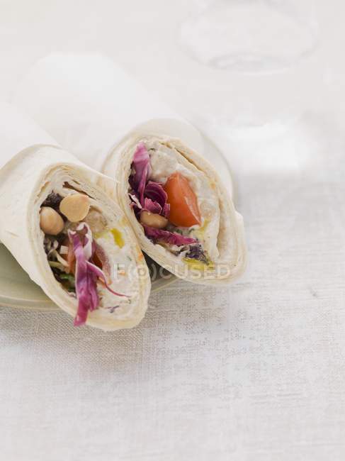 Wraps filled with houmous and tomatoes  on white surface — Stock Photo